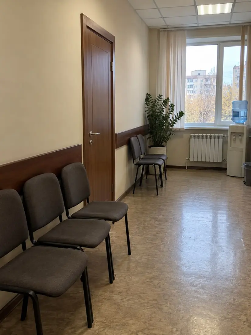 Пустой коридор нотариальной конторы со стульями у стены